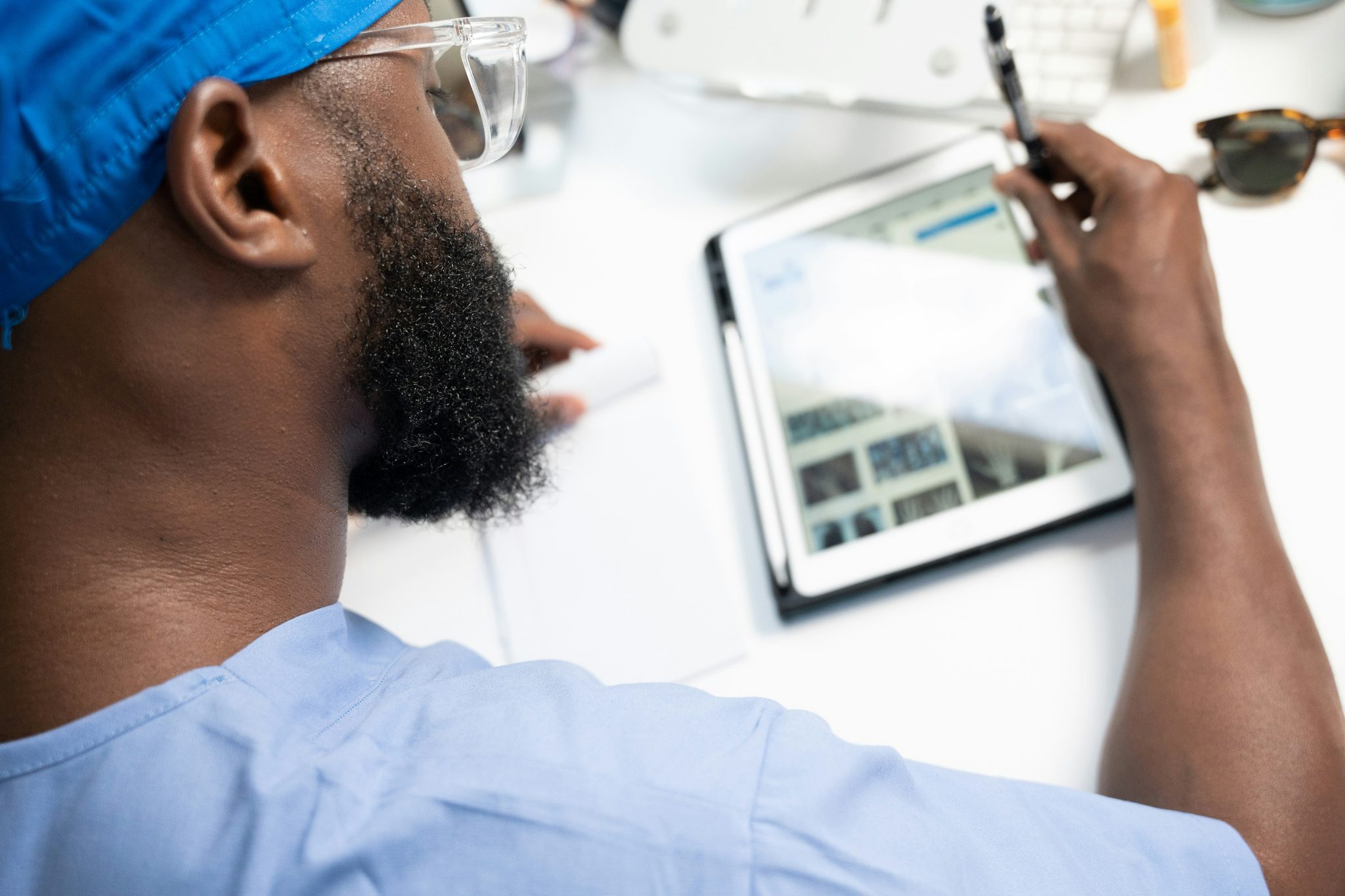 Clinician in scrubs reviewing imaging results on a tablet