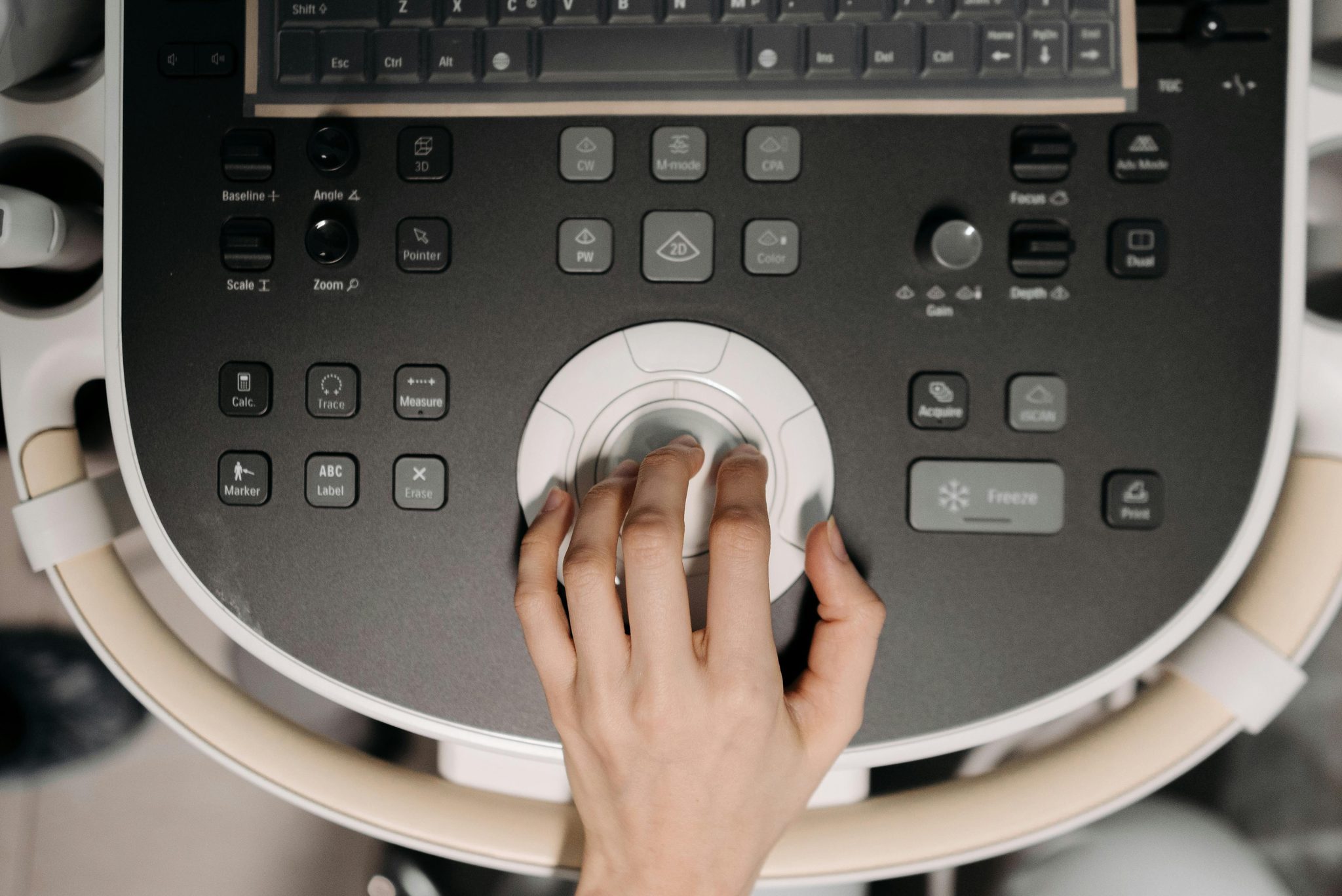 Sonographer operating the control panel of an ultrasound machine